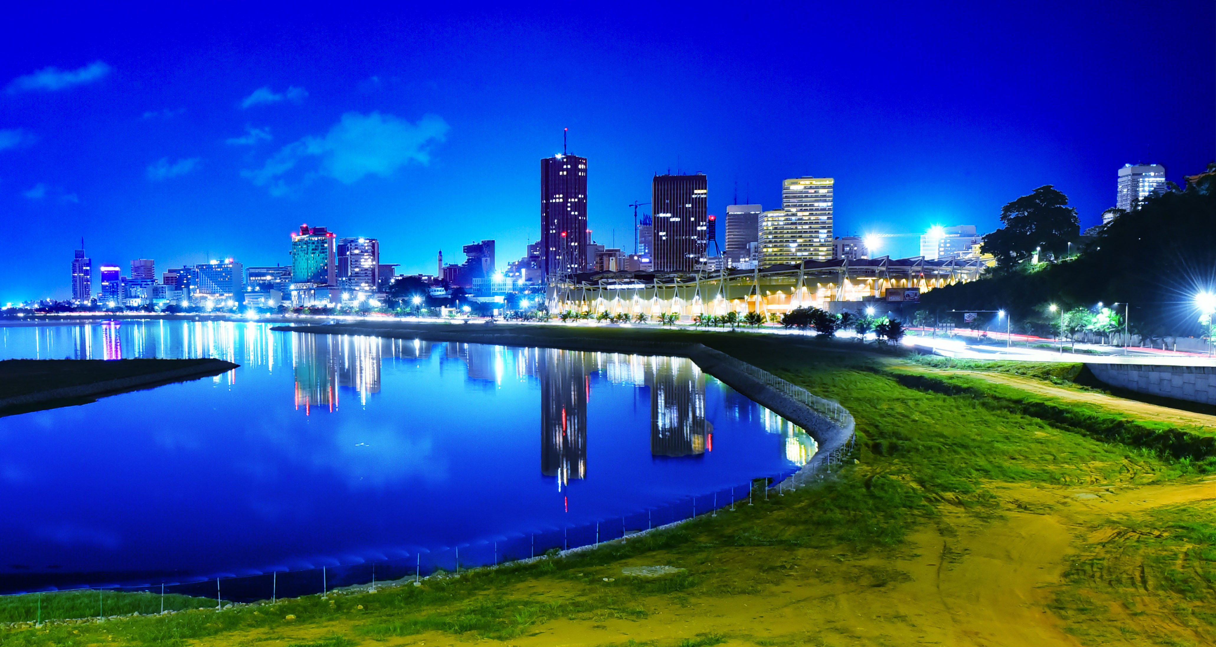 Abidjan’s illuminated Plateau skyline and waterfront photographed from the western end of the ADO bridge at night