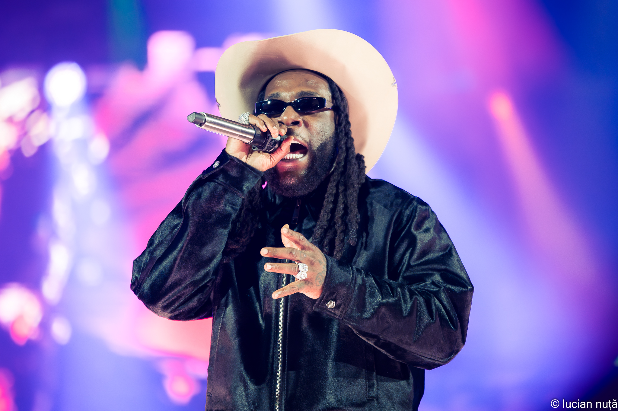Burna Boy singing into a microphone at Untold festival in 2024
