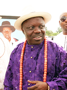 Emmanuel Uduaghan wearing a cream hat, purple agbada and coral beads at a 2012 ceremony in Warri