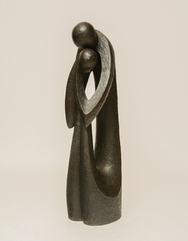 Tall carved wooden sculpture of a mother encircling a child